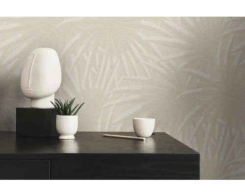 Szene mit einer gemusterten Tapete, einer Skulptur, einer Zimmerpflanze und einer Tasse auf einem schwarzen Tisch