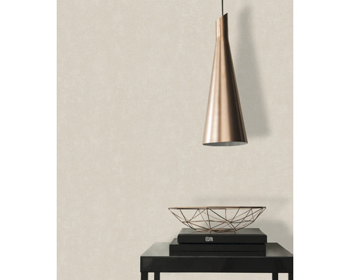 Szene mit Pendelleuchte, Dekoschale und Büchern auf einem Tisch vor einer Tapete