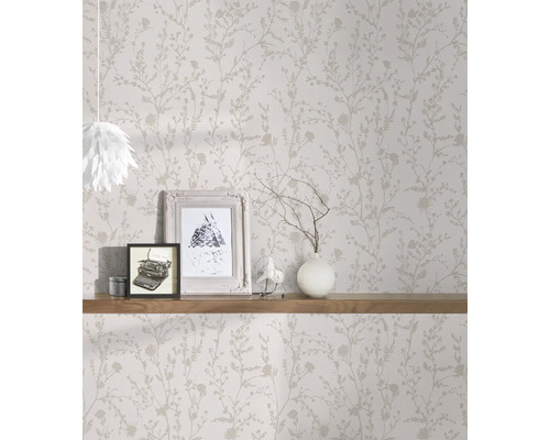 Raumansicht mit floral gemusterter Tapete und Dekoration auf einem Holzregal.