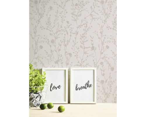 Szene mit Blumentapete, zwei Bilderrahmen, einer Pflanze und Limetten