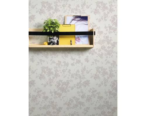 Wand mit floral gemusterter Tapete und Regal mit Dekoration