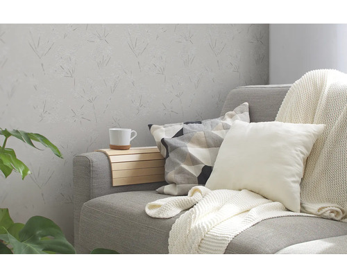 Wohnzimmer mit Sofa, Kissen und floral gemusterter Tapete