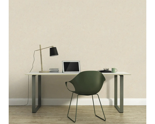 Arbeitszimmer mit Schreibtisch, Stuhl und Lampe vor einer gemusterten Wand.