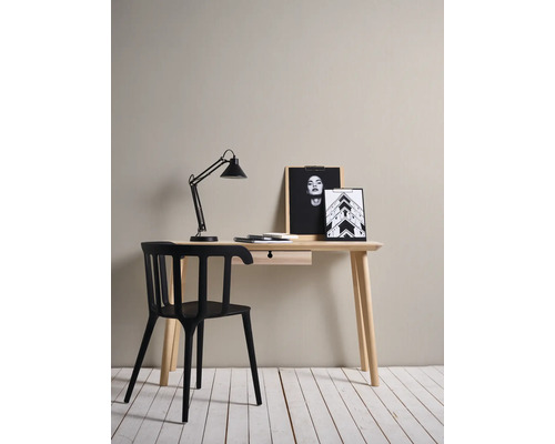 Bureau avec chaise noire, lampe de bureau et images décoratives sur une surface en bois.