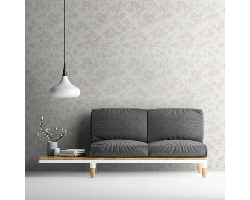 Einrichtung mit Sofa vor einer mit floralem Muster bedruckten Tapete.