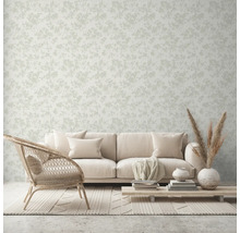 Wohnraum mit Couch, Sessel, Tisch und floral gemusterter Tapete.