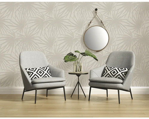 Salon avec deux fauteuils gris, petite table, miroir et papier peint à motifs