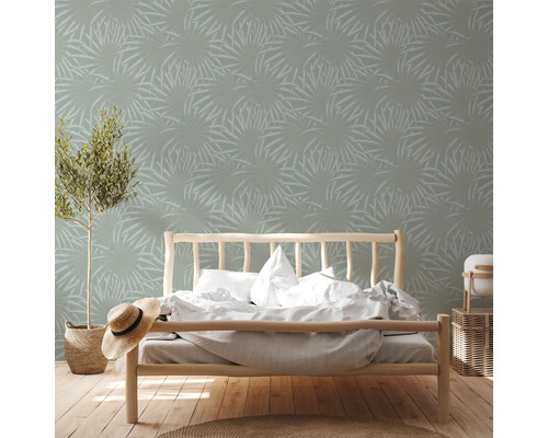 Schlafzimmer mit Bett und Tapete mit Pflanzenmuster