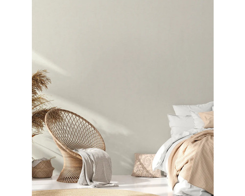 Helles Schlafzimmer mit Rattan Sessel, Bett und Dekoration