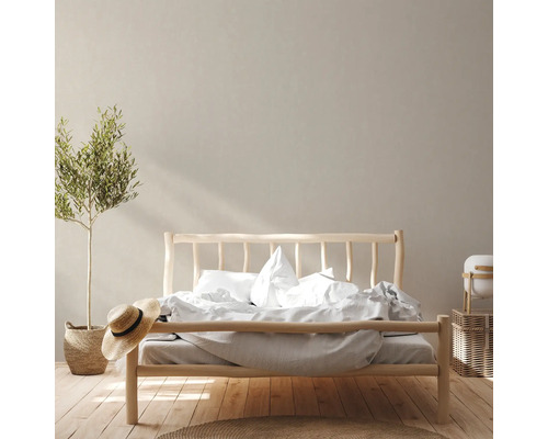 Schlafzimmer mit Holzbett, Bettwäsche, Zimmerpflanze und Dekoration