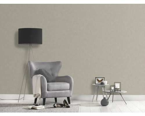 Salon avec papier peint structuré beige, fauteuil et lampadaire