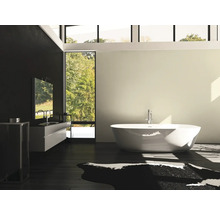 Badezimmer mit freistehender Badewanne, Waschtisch und großem Fenster