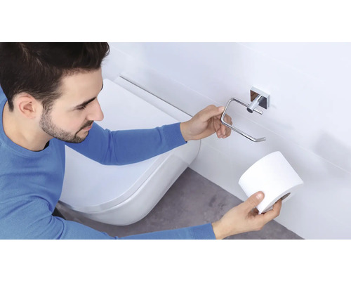Mann wechselt Toilettenpapier auf Toilettenpapierhalter