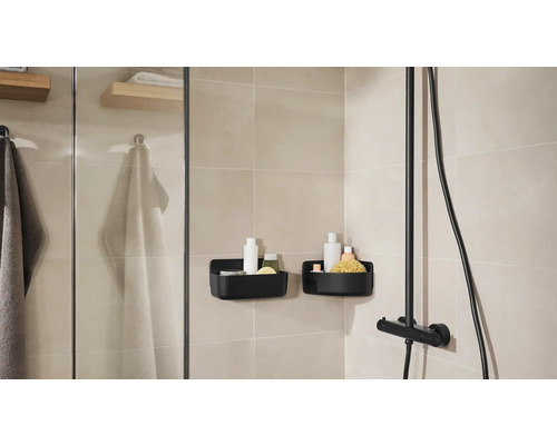 Badezimmer mit Dusche, Handtüchern und zwei schwarzen Duschkörben zur Aufbewahrung von Badartikeln