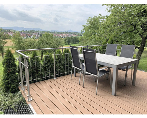 Terrasse avec table à manger, chaises et rambarde dans le jardin