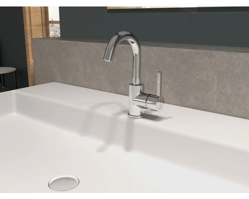 Un robinet brillant se trouve sur un lavabo.