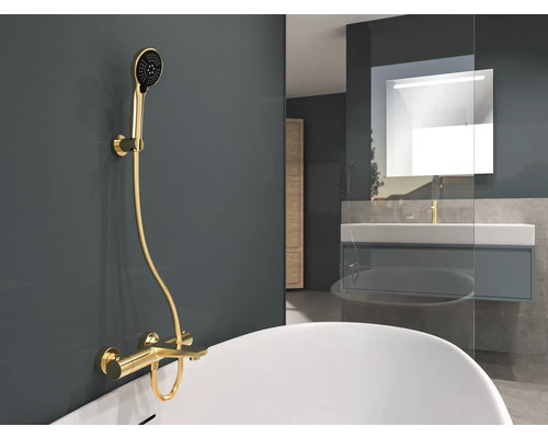 Badezimmer mit goldener Duscharmatur und Waschtisch