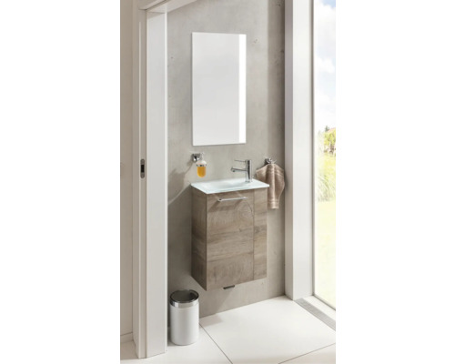 Salle de bains avec meuble sous-lavabo, miroir, distributeur de savon, serviette et poubelle