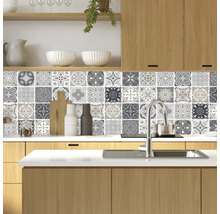Küchenszene mit Mosaikfliesen-Wanddekoration, Spüle und Holzelementen.