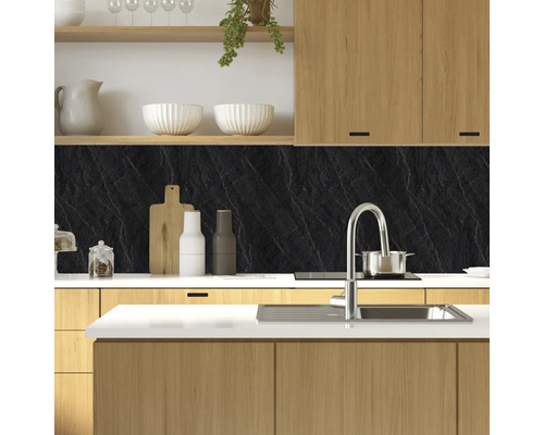 Küchenszene mit Küchenarmatur, Spüle, Kochfeld und Arbeitsplatte mit schwarzer Küchenrückwand in Schieferoptik