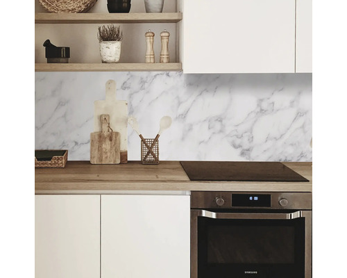 Scène de cuisine avec plan de travail, évier, cuisinière et revêtement mural en marbre blanc