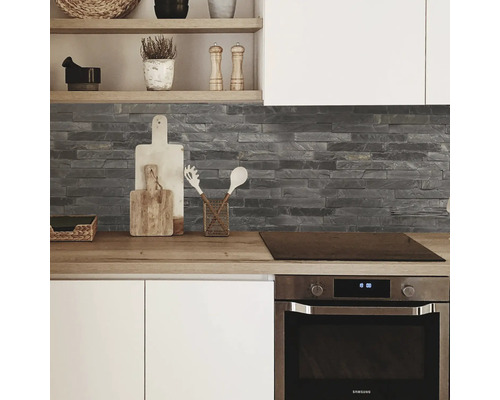 Küchenansicht mit Arbeitsplatte, Steinwand und Einbauherd