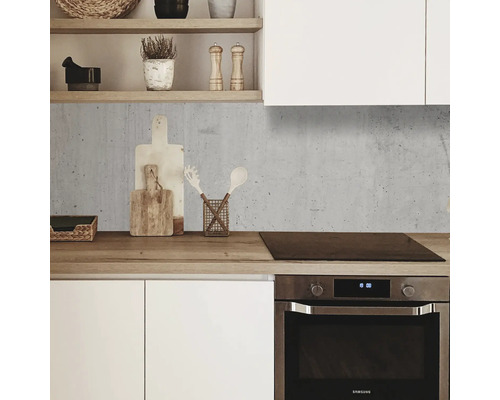 Küchenszene mit Betonrückwand, Holzarbeitsplatte und weißen Schränken