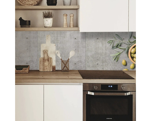 Küchenszene mit Betonrückwand, Kochfeld und Küchenutensilien