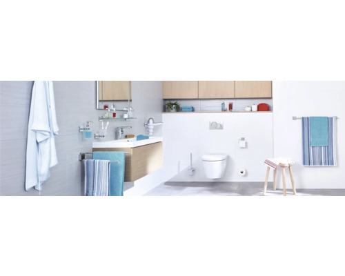 Helles Badezimmer mit Waschtisch, Toilette und Handtüchern.