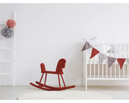 Kinderzimmer mit Kinderbett, rotem Schaukelpferd und Leiter