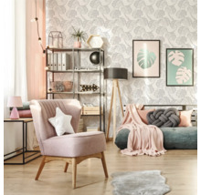 Wohnzimmer mit Sessel, Regal und Zimmerpflanzen vor einer Tapete mit Blattmuster
