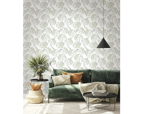 Salon avec canapé vert, tables d''appoint et papier peint à motifs de feuilles