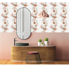 Aménagement de salle de bains avec lavabo, miroir, lampe et papier peint à motifs floraux