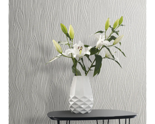 Gemusterte Tapete mit floralem Arrangement in Vase auf Tisch