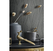 Dekorative Szene mit gemusterter Tapete, Vase, Tasse und goldfarbener Pfauenfigur