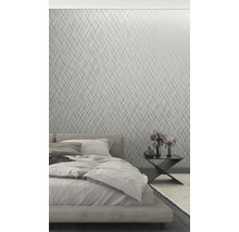 Schlafzimmer mit geometrischer Tapete, Bett und Nachttisch