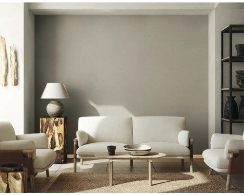 Salon avec canapé, fauteuils, table, lampe et étagère.