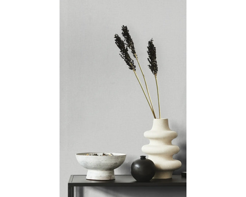 Dekorative Anordnung mit Vase, Ziergras und Schale auf einem Tisch