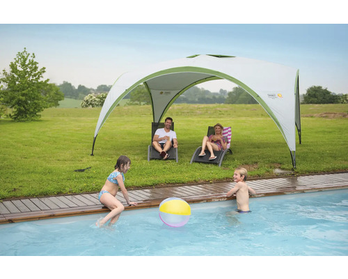 Scène avec pavillon, chaises longues et enfants jouant à la piscine dans le jardin.
