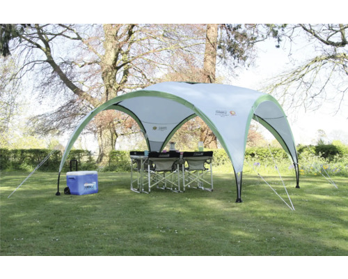 Tente de réception Coleman Event Shelter Pro avec table, chaises et glacière dans le jardin