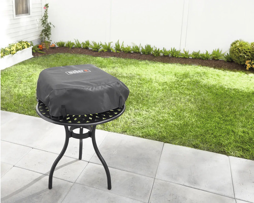 Logo Weber sur housse de barbecue dans le jardin