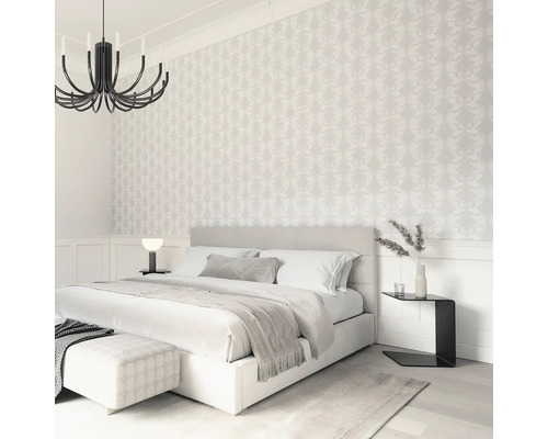 Schlafzimmer mit Doppelbett, Nachttisch und gemusterter Tapete