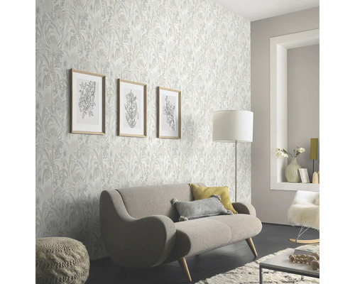 Wohnzimmer mit floral gemusterter Tapete, Sofa und Dekorationen für eine helle und freundliche Atmosphäre.