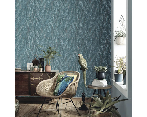 Salon avec papier peint à motifs, fauteuil en rotin et décoration