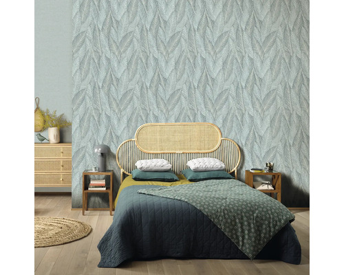 Schlafzimmer mit Blattmuster-Tapete, Rattan-Bettrahmen und Holzboden