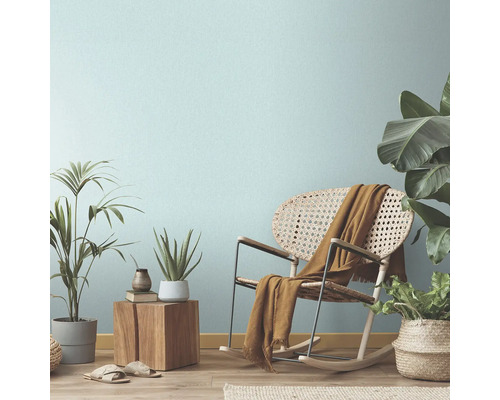 Wohnzimmer-Szene mit Schaukelstuhl, Pflanzen und dekorativen Elementen für eine gemütliche Atmosphäre.