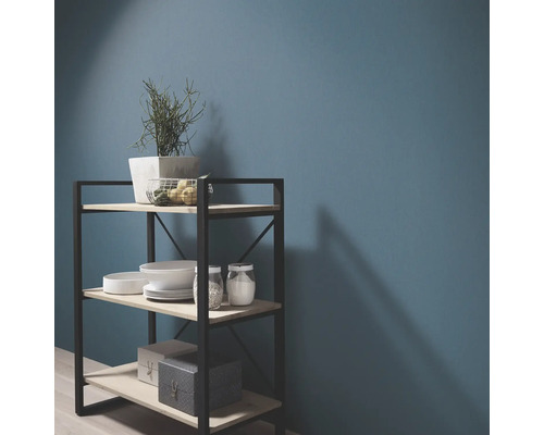 Étagère à trois niveaux avec vaisselle et décoration devant un mur