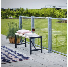 Banc avec cadre en métal, coussin, livres et verre à vin sur une terrasse