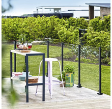 Scène de jardin avec clôture en verre, table de bar et tabouret de bar sur terrasse en bois