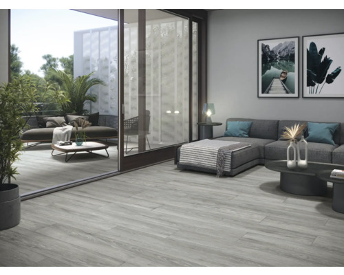 Salon avec carrelage de sol gris imitation bois et accès au balcon